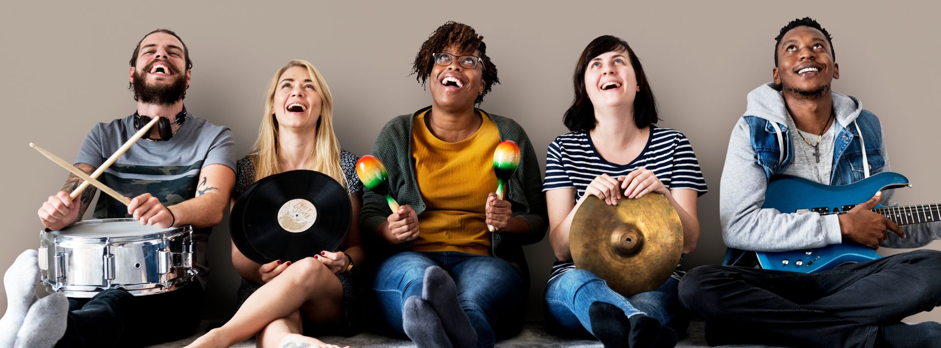 three ladies and one man, each holding a musical instrument